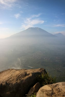 Arkasında dağ olan bir uçurum. Kaya kayalığı dağ taşının bir parçası. Boş uzay uçurumunun kenarında bulutların üzerinde mavi gökyüzü.