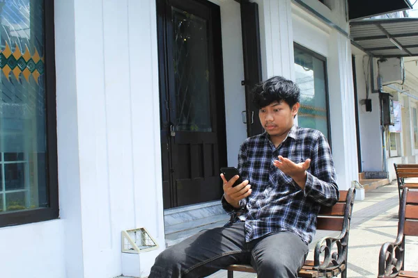 Pemuda Asia Bodoh Mengenakan Kemeja Flanel Biru Dan Duduk Bangku — Stok Foto