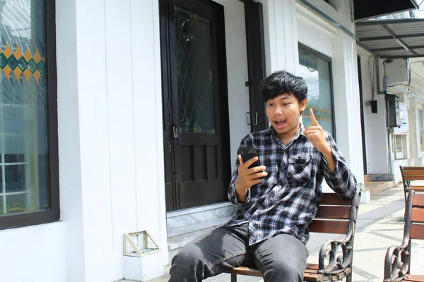 아시아인 남자는 스마트폰을 의자에 때멋진 아이디어를 얻었습니다 — 스톡 사진