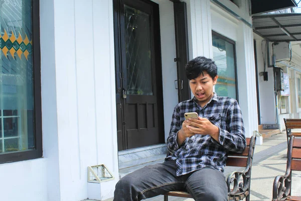 Schockiert Und Überrascht Sitzt Ein Junger Asiatischer Mann Blauen Flanellhemden — Stockfoto