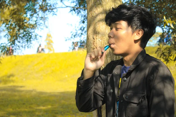 Relaxing Young Asian Man Wear Black Jacket Inhale Blue Vape — Stock Photo, Image