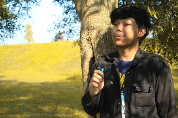 Entspannter Junger Asiatischer Mann Bläst Vape Pod System Produzieren Wolke — Stockfoto