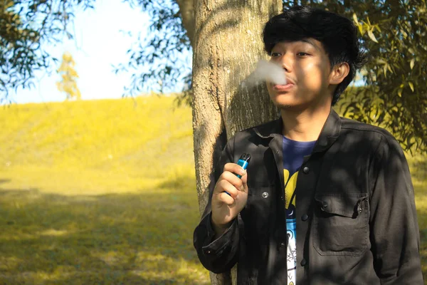 Розслаблений Молодий Азіатський Чоловік Дме Систему Вейп Стрічок Виробляє Хмари — стокове фото
