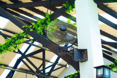 Duvarda çelik tavan, yeşil yaprak fabrikası ve yeşil evle elektrikli vantilatör. 