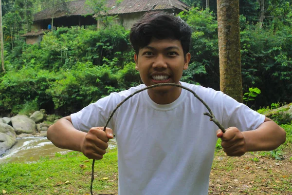 Uśmiechnięty Młody Człowiek Azjatycki Łamie Trea Gałąź Rzece Tropikalny Las — Zdjęcie stockowe