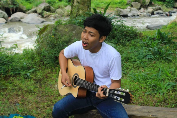 Щасливий Молодий Азіатський Чоловік Грає Акустичній Гітарі Співає Березі Річки — стокове фото