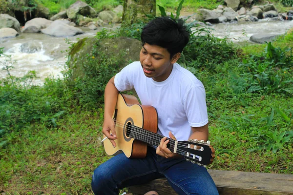 Счастливый Молодой Азиат Играет Акустической Гитаре Поет Берегу Реки Время — стоковое фото