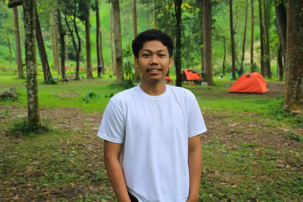 亚洲年轻人面带微笑 站在热带营地 穿着白色T恤衫享受假期 印度年轻人徒步旅行和露营 — 图库照片