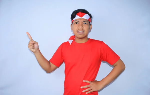 Boze Indonesische Jongeman Wijst Zijn Wijsvinger Omhoog Rood Shirt Hoofdband — Stockfoto