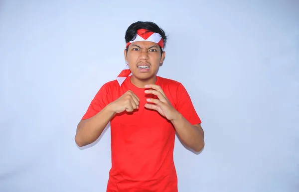 在印度尼西亚独立日 愤怒的印尼年轻人戴着红色T恤和头巾举起双手 用拳头击打自己的手掌 — 图库照片