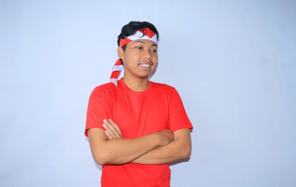 インドネシアの若者は 赤いTシャツとヘッドバンドを着て インドネシアの独立記念日を祝う交差した手で微笑んでいる — ストック写真