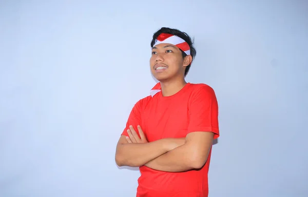 インドネシアの若者は 赤いTシャツとヘッドバンドを着て インドネシアの独立記念日を祝う交差した手で微笑んでいる — ストック写真