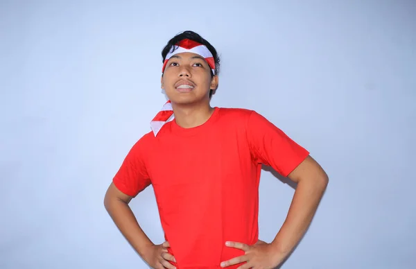 インドネシアの若者は赤いTシャツとヘッドバンドを着て インドネシアの独立記念日を祝うウエストの手で笑っている — ストック写真