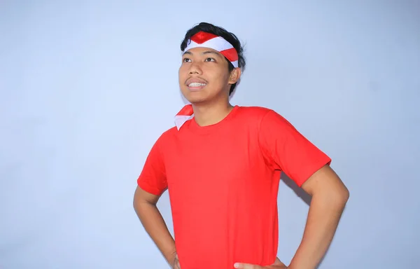 インドネシアの若者は赤いTシャツとヘッドバンドを着て インドネシアの独立記念日を祝うウエストの手で笑っている — ストック写真