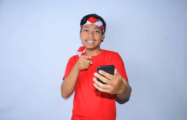 Gülümseyen Endonezyalı Genç Adam Mutlu Heyecanlı Yüzüyle Cep Telefonunu Işaret — Stok fotoğraf