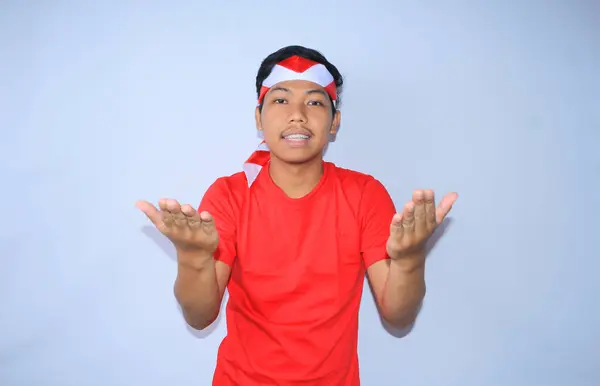 Indonezyjski Młody Mężczyzna Pokazuje Wyimaginowany Produkt Lub Prezentuje Spokojną Szczęśliwą — Zdjęcie stockowe