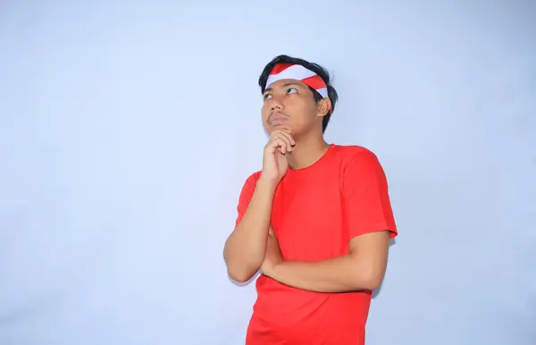 Přemýšlivý Indonéský Mladý Muž Přemýšlející Podezřívavý Rukama Bradě Červené Tričku — Stock fotografie