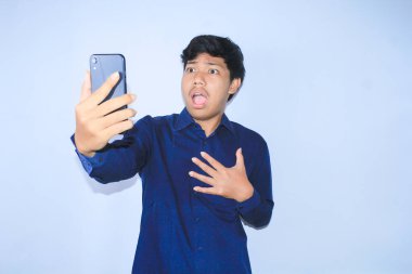 Asyalı genç adam akıllı telefonuna bakıp göğsünü tutarak kötü haberler okuduğunda şaşırdı.