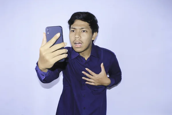 Asijský Mladý Muž Překvapen Když Dívá Svůj Smartphone Číst Špatné — Stock fotografie