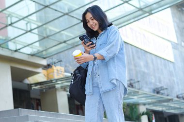 Çekici, güzel Asyalı genç kadın nüfuzlu kişi video kaydetmekten, video izlemekten ya da küçük işletme sosyal medya içerikleri için bir fincan kahve çekmekten hoşlanıyor.