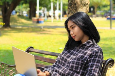 Sakin ol Asyalı genç bayan. Laptop kullanarak gülümse. Serbest çalış ve mutlu ol.