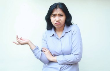 Şaşırmış Asyalı genç iş kadını beyaz arka planda izole edilmiş kameraya bakarak avuçlarını ve omuzlarını silkeliyor.