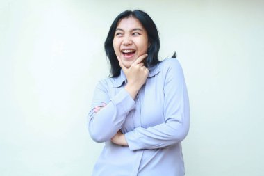 Tasasız Asyalı genç iş kadınının portresi. Çene ve katlanmış kollarıyla heyecanlı bir şekilde beyaz arka planda izole edilmiş resmi mor bir takım elbise giyiyor.