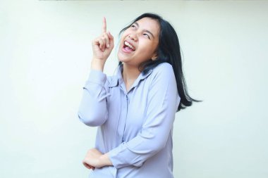 Heyecanlı Asyalı resmi takım elbiseli genç iş kadınının portresi boşluğu işaret ediyor ve pazarlama için jest yapıyor, beyaz arka planda tek başına duran bir kadın.