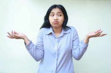 Hiçbir fikrim yok ya da belki bir jest. Cahil Asyalı genç iş kadını avuçlarını yana doğru açıyor. Resmi gömleği giyip yalıtılmış beyaz arka planda dikiliyor.