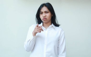 Stüdyoda üzgün genç Asyalı kadın ofis müdürünün görüntüsü. Mutsuz bir yüz ifadesiyle kameraya işaret ediyor. Hatalar için seni suçluyor mu?