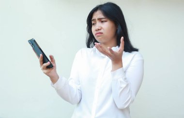 Hiçbir şey bilmeyen Asyalı kadın yöneticinin portresi. Akıllı telefonu elinde tutuyor. Jestleri, üzgün ifadeleri, sosyal medyada sörf ve online alışverişi bilmiyor.