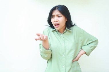 Ayrı beyaz arka planda duran, avuçlarını kaldırıp beline bakan Asyalı bir kadının çekimleri sorgulama hareketi ve çılgın bir ifade sergiliyor.