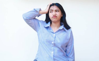 Çizgili tişört giyen düşünceli Asyalı kadın, elleri çenesinde, kolları beyaz arka planda olan tuhaf bir ifade sergiliyor.