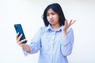 Kafası karışmış Asyalı bir kadın cep telefonu kullanıyor. Avuç içi kaldırıyor. Sinirli yüz ifadesini bilmiyor.