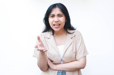 Asyalı sinirli bir kadın avuç içi kaldırıyor kızgın bir yüz ifadesiyle beyaz arka planda izole edilmiş günlük giysiler giyiyor.