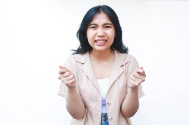 Asyalı sinirli bir kadın avuç içi kaldırıyor kızgın bir yüz ifadesiyle beyaz arka planda izole edilmiş günlük giysiler giyiyor.