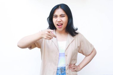 Asyalı sinirli kadın kameraya elleri belinde beyaz arka planda izole edilmiş günlük kıyafetler giyiyor.