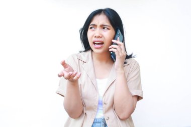 Asyalı kızgın kadın kıvrık parmaklı akıllı telefon kullanıyor beyaz arka planda izole edilmiş günlük kıyafetler giyiyor sosyal medyada kötü haber okuyan bir kadın.