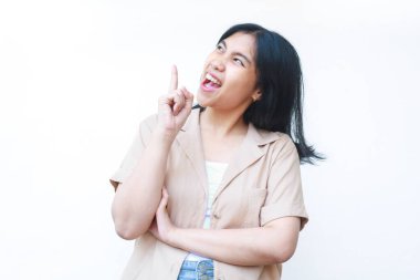 Heyecanlı Asyalı kadın beyaz arka planda izole edilmiş günlük kıyafetler giyerek jest yapıyor.