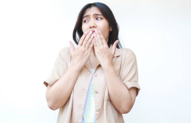 Şok olmuş Asyalı kadın beyaz arka planda izole edilmiş günlük kahverengi kıyafetler giyiyor.