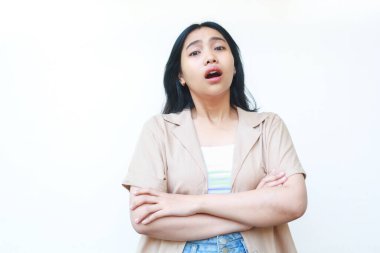 Şok olmuş Asyalı kadın kameraya çapraz elle bakıyor beyaz arka planda izole edilmiş günlük kıyafetler giyiyor.