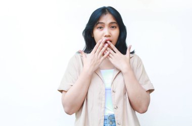 Şok olmuş Asyalı kadın beyaz arka planda izole edilmiş günlük kahverengi kıyafetler giyiyor.