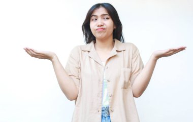 Düşünceli Asyalı kadın beyaz arka planda izole edilmiş günlük kahverengi kıyafetler giyiyor.