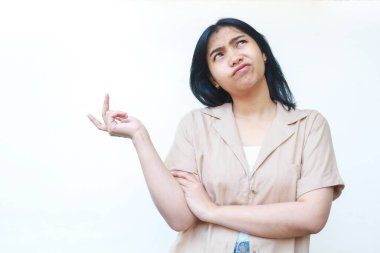 Düşünceli Asyalı kadın beyaz arka planda izole edilmiş günlük kahverengi kıyafetler giyiyor.