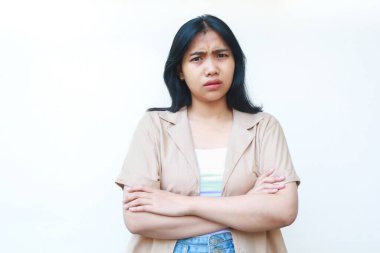 Düşünceli Asyalı kadın beyaz arka planda izole edilmiş günlük kahverengi kıyafetler giyerek ciddi ciddi düşünüyor.