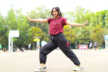 Mutlu Asyalı kadın basketbol oynamadan önce elini uzatıp ısınıyor.