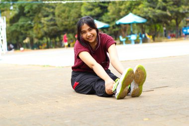 Mutlu Asyalı kadın voleybol sahasında yoga yapıyor.