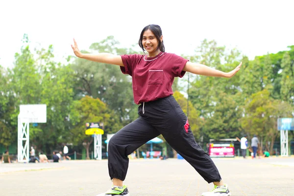 happy asian woman stretching hands in outdoor warm up before play basketball