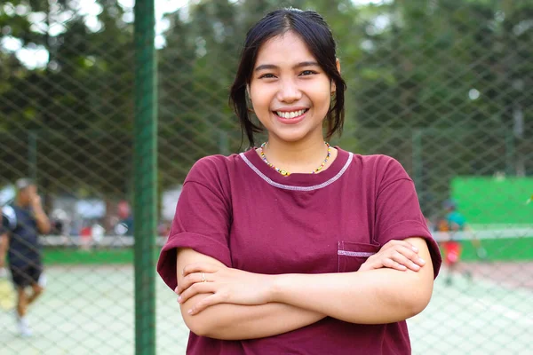 Szczęśliwy Azji Kobieta Stoi Kort Tenisowy Krzyżowymi Ramionami Patrzeć Aparat Zdjęcia Stockowe bez tantiem
