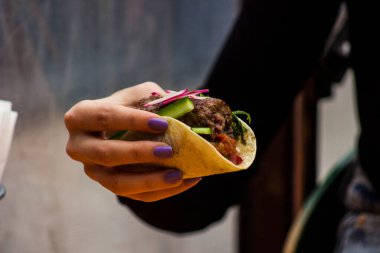 Hamburgerle sandviç yiyen bir adama yaklaş.